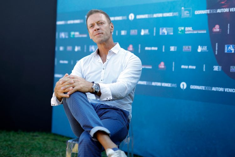 Rocco Siffredi seduto a gambe incrociate