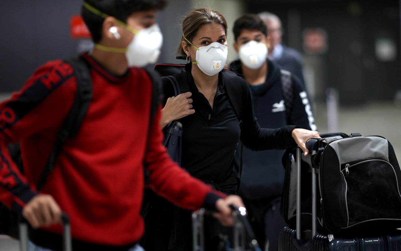 Viaggatori indossano la mascherina in aeroporto